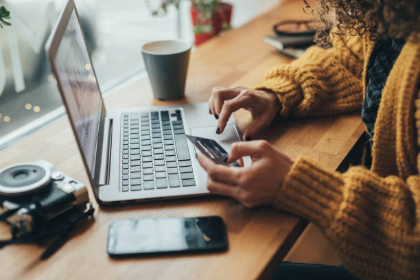 Person using a laptop and holding a credit card, representing online business transactions in the UAE.