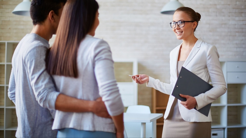 A real estate agent shows a property to a couple.