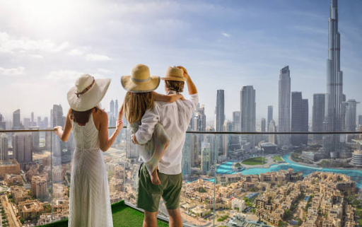 Three people enjoy a high-rise view of a modern city skyline, symbolizing business opportunities in RAKEZ Free Zone.